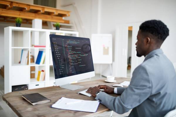 A man working with code on a mac computer